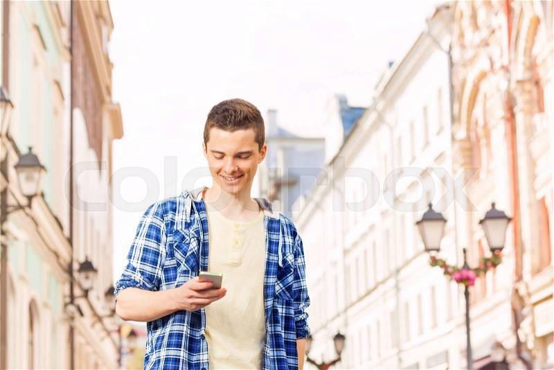 Young man with cell phone on the street during summer vacation time in Europe, stock photo