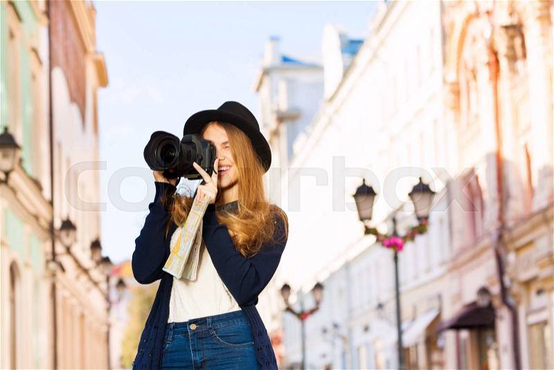 Beautiful young woman shooting with camera touristic attractions on the European street during summer day time, stock photo