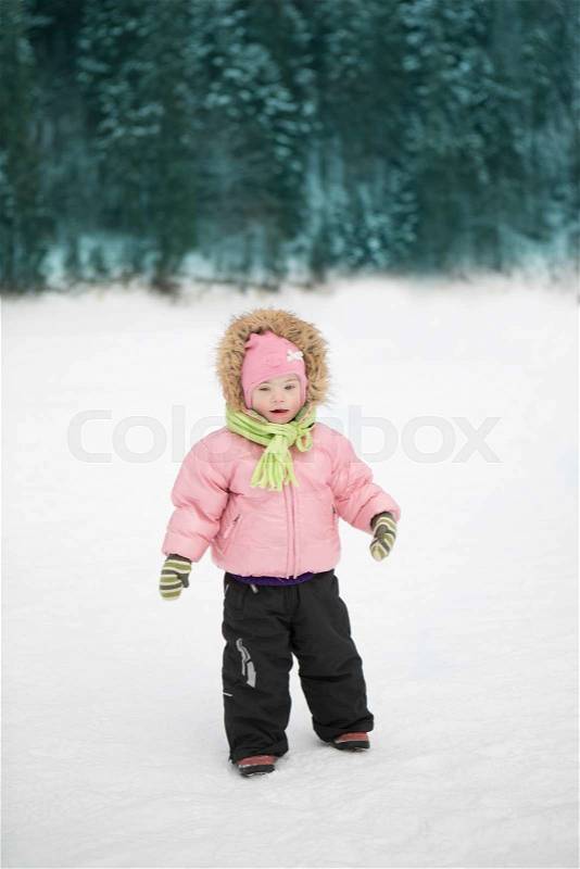 Beautiful girl with Down syndrome alone walking in the park in winter, stock photo