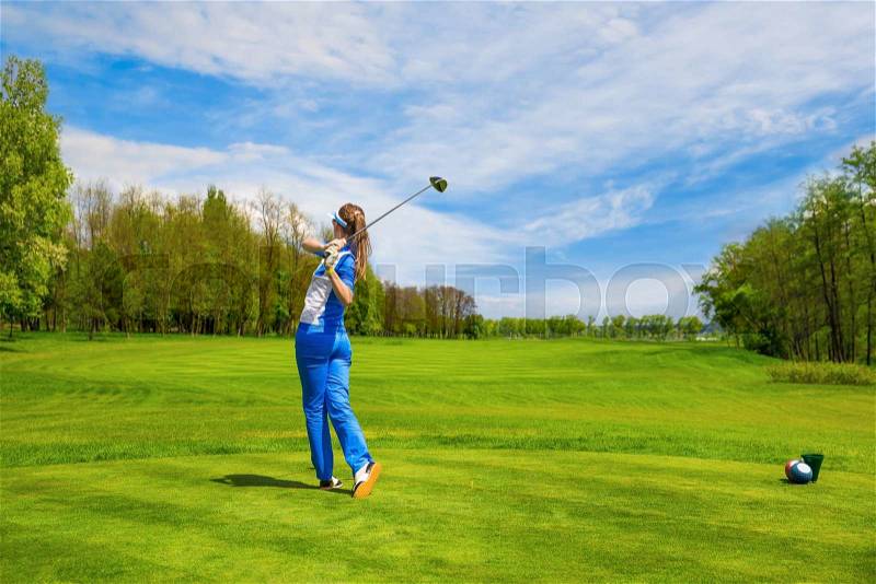 Woman golf player hitting by iron from fairway, stock photo