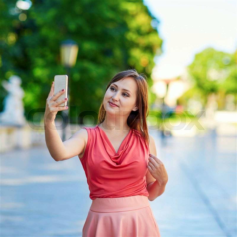Beautiful young woman walking in Vienna, Austria and taking selfie, stock photo
