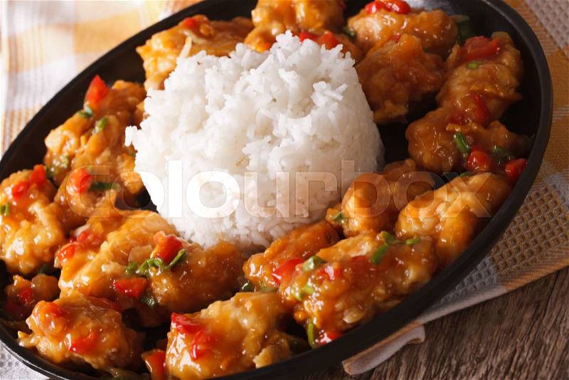 Orange chicken with sauce and rice closeup on a plate. horizontal , stock photo