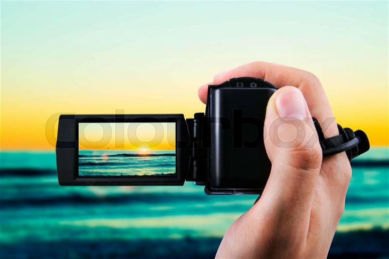 Video camera or camcorder recording sunset, stock photo