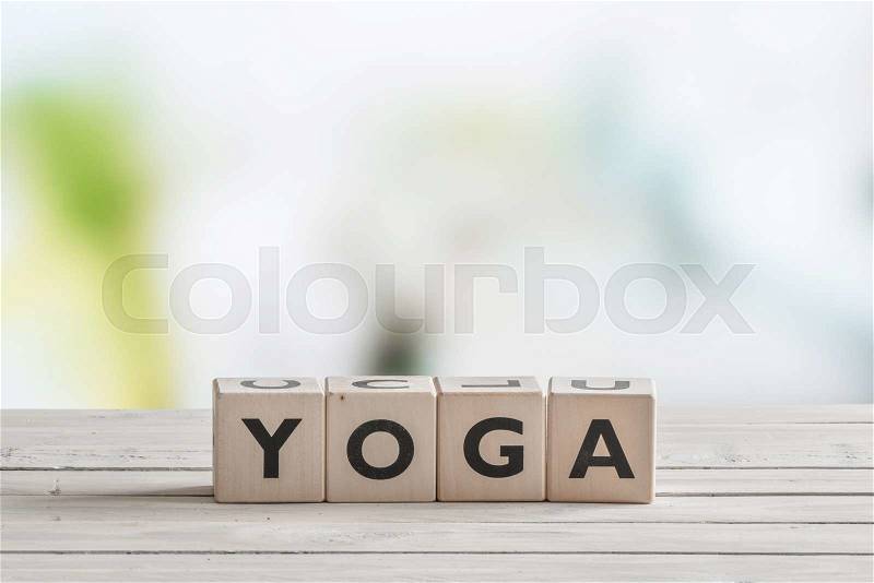 Yoga sign made of cubes on a wooden desk, stock photo