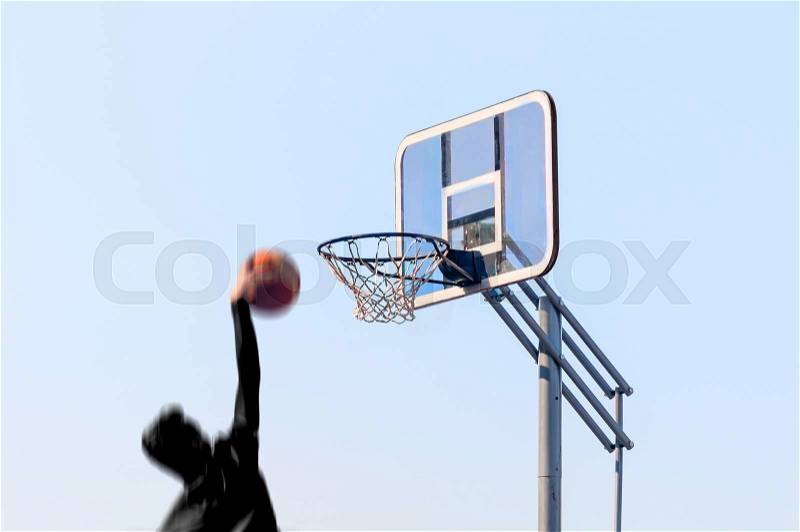 Athlete throws the ball into a basketball basket, stock photo