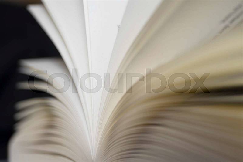 Open book with pages and shallow depth of field with black background, stock photo