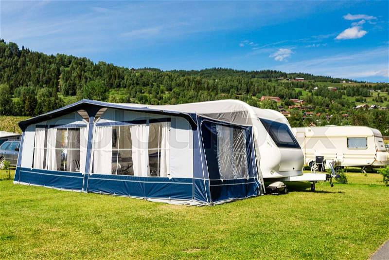 Modern caravan with caravan tent at campsite in Norway on a sunny summer day, stock photo