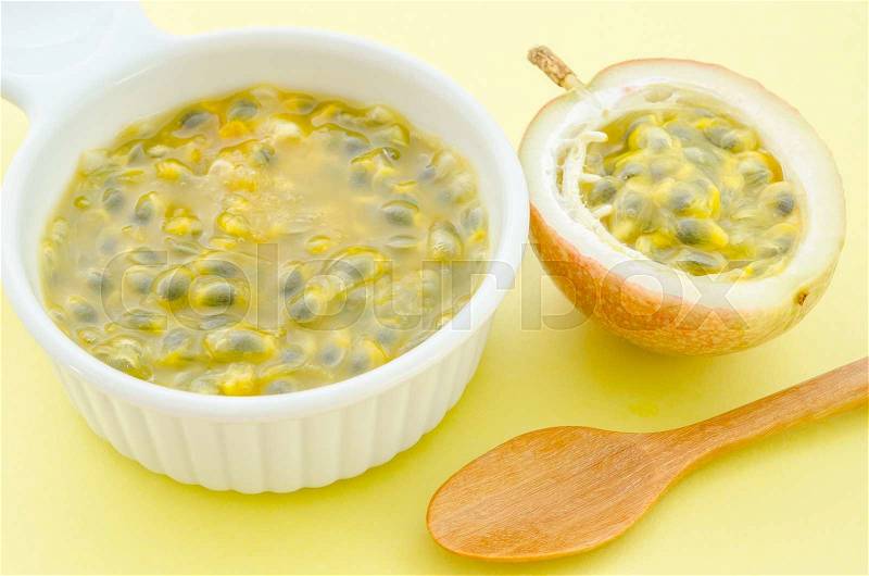 Maracuja, passion-fruit juice in white bowl with wooden spoon, stock photo