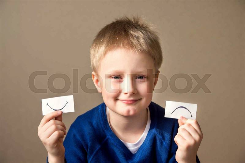 Young boy select between positive and negative expressions, stock photo