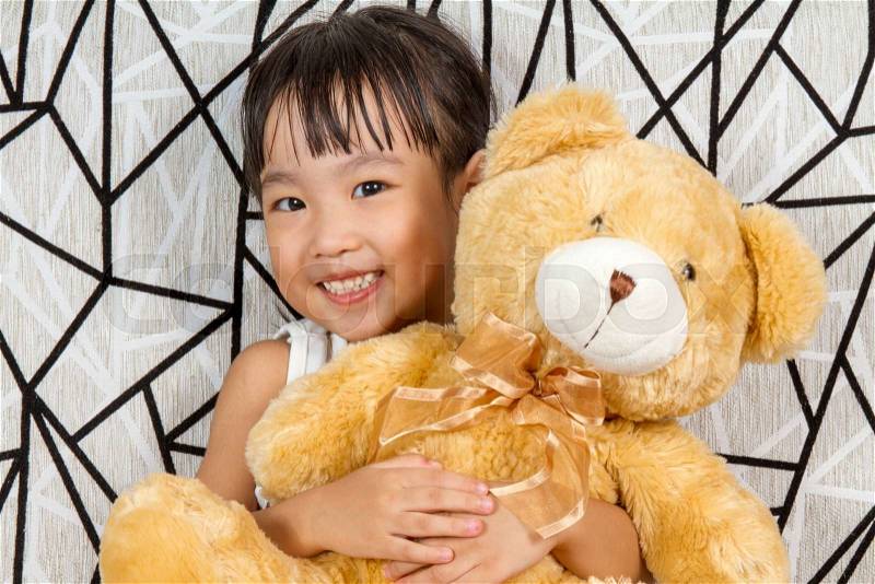 Asian Little Chinese Girl with Teddy Bear at Home, stock photo