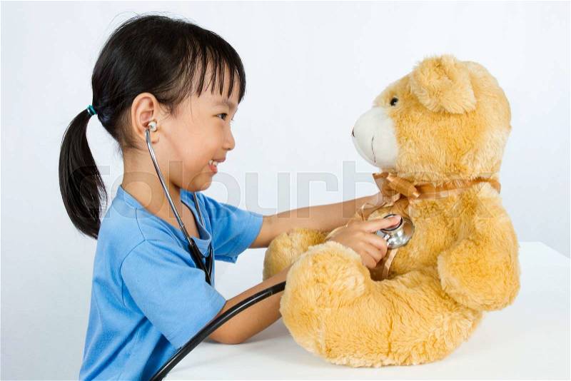 Asian Little Chinese Girl Playing Doctor with Teddy Bear isolated on white background, stock photo