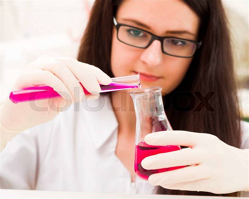 Young sweet student being occupied with chemical analysis, stock photo