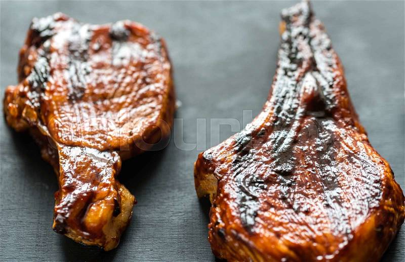 Grilled pork ribs on the wooden background, stock photo