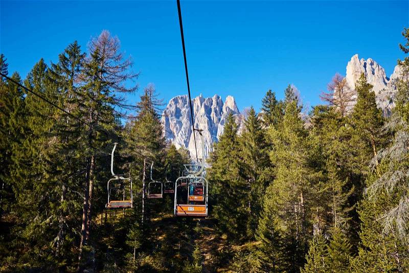 Beautiful view of ski lift among the woods over the rocks. italy dolomieten, stock photo