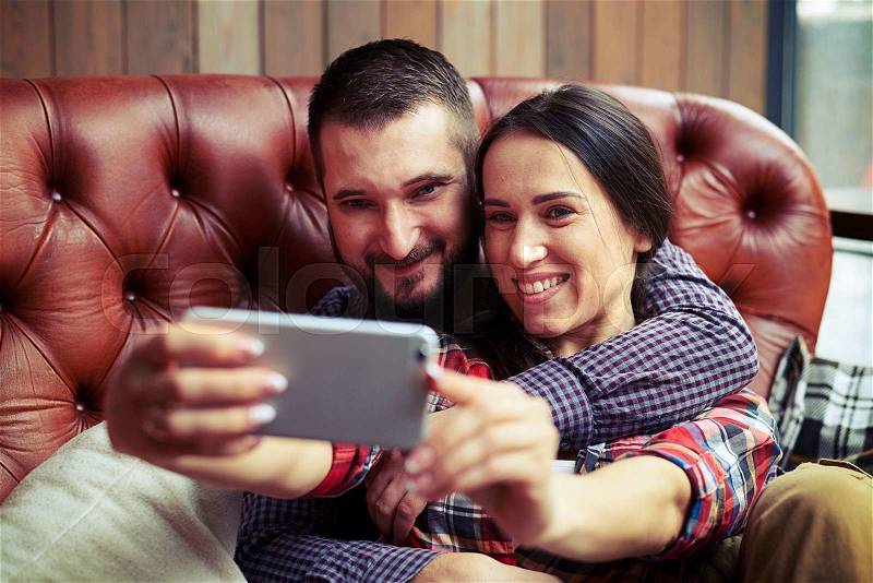 Smiley couple taking selfie picture by the phone, stock photo