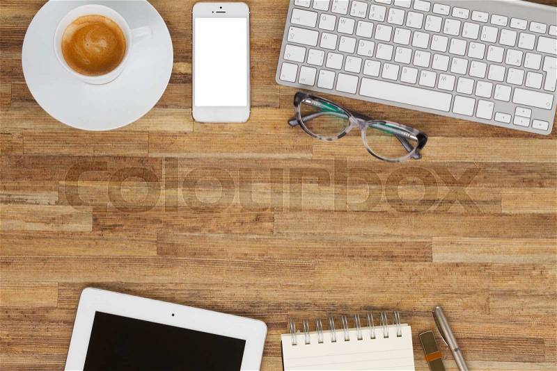 Office styled desktop frame with coffee, mobile, tablet and keyboard, stock photo