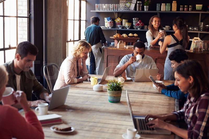 Interior Of Coffee Shop With Customers Using Digital Devices, stock photo