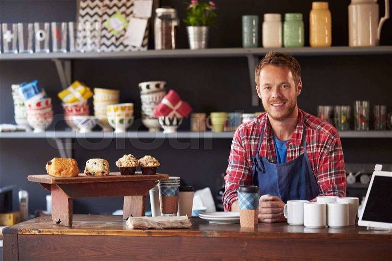 Portrait Of Male Coffee Shop Owner Standing Behind Counter, stock photo