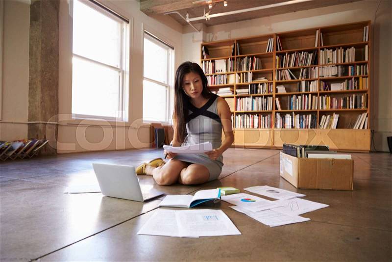 Businesswoman Laying Documents On Floor To Plan Project, stock photo