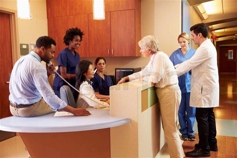 Medical Staff At Busy Nurse\'s Station In Hospital, stock photo