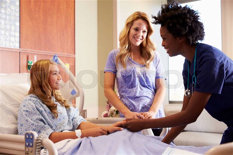 Nurse Talks To Mother With Teenage Daughter In Hospital, stock photo