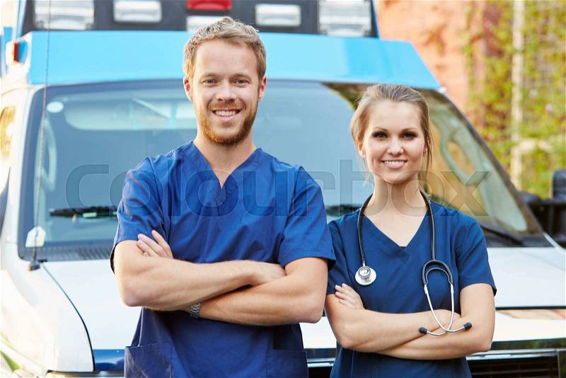 Portrait Of Medical Staff Standing In Front Of Ambulance, stock photo