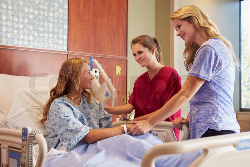Nurse Talks To Mother With Teenage Daughter In Hospital, stock photo
