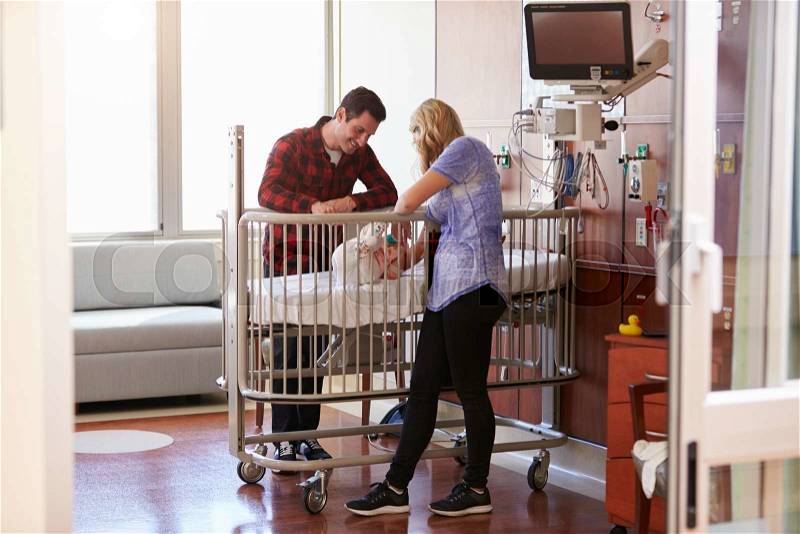Parents With Daughter In Hospital Pediatric Unit, stock photo