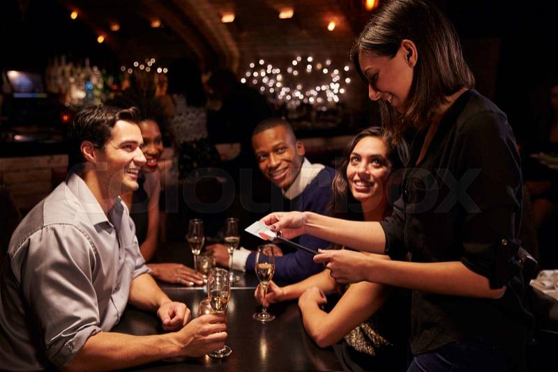 Waitress Takes Payment For Restaurant Bill On Digital Tablet, stock photo