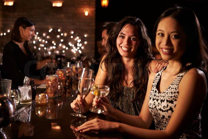 Portrait Of Female Friends On Night Out At Cocktail Bar, stock photo