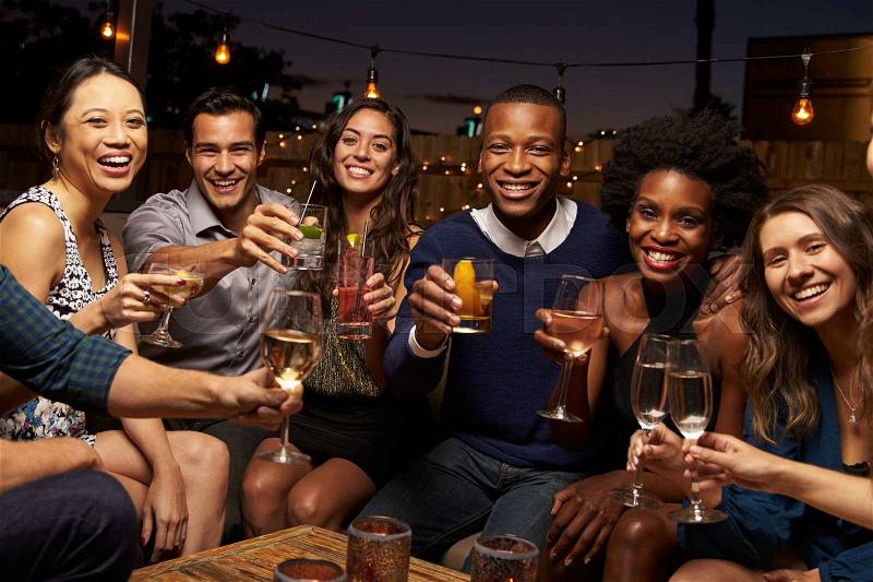 Portrait Of Friends Enjoying Night Out At Rooftop Bar, stock photo