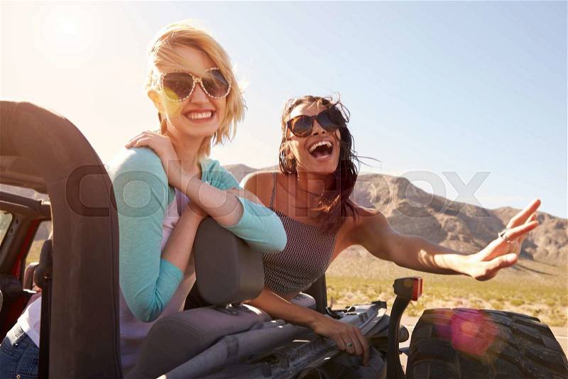 Two Female Friends On Road Trip In Back Of Convertible Car, stock photo