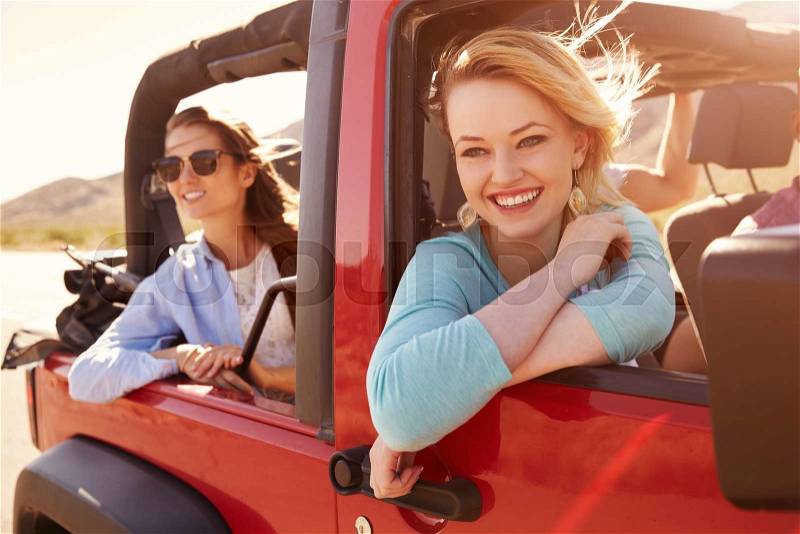 Two Female Passengers On Road Trip In Convertible Car, stock photo