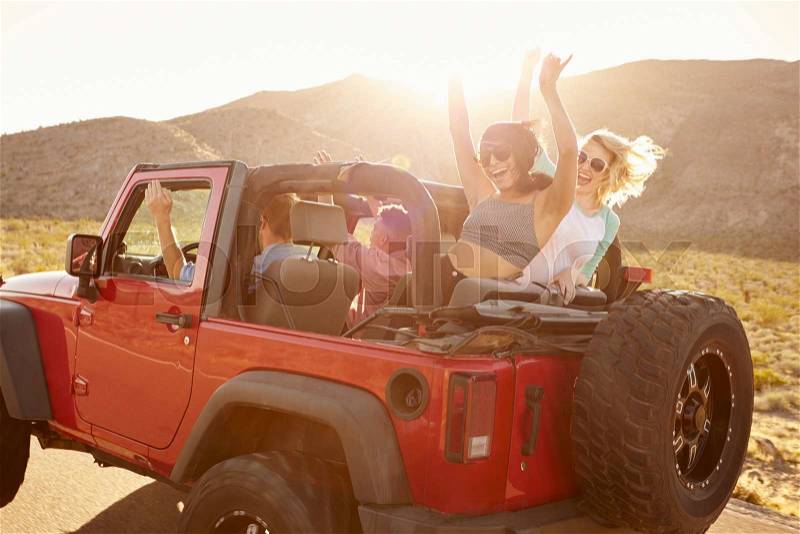 Friends On Road Trip Driving In Convertible Car, stock photo