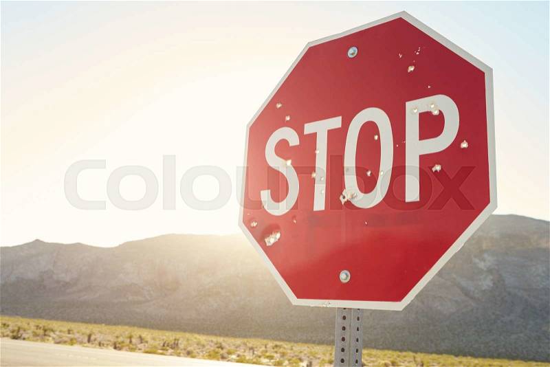 Stop Traffic Sign With Bullet Holes On Country Road, stock photo