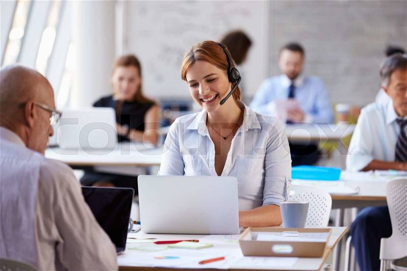 Businesswoman Using Laptop In Customer Service Department, stock photo
