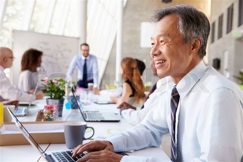 Asian Businessman At Board Meeting With Colleagues, stock photo