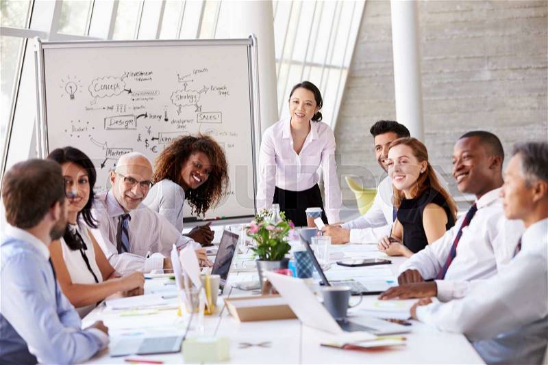 Asian Businesswoman Leading Meeting At Boardroom Table, stock photo