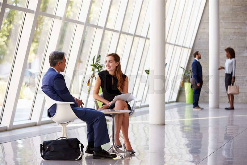 Business Meeting In Busy Office Foyer Area, stock photo