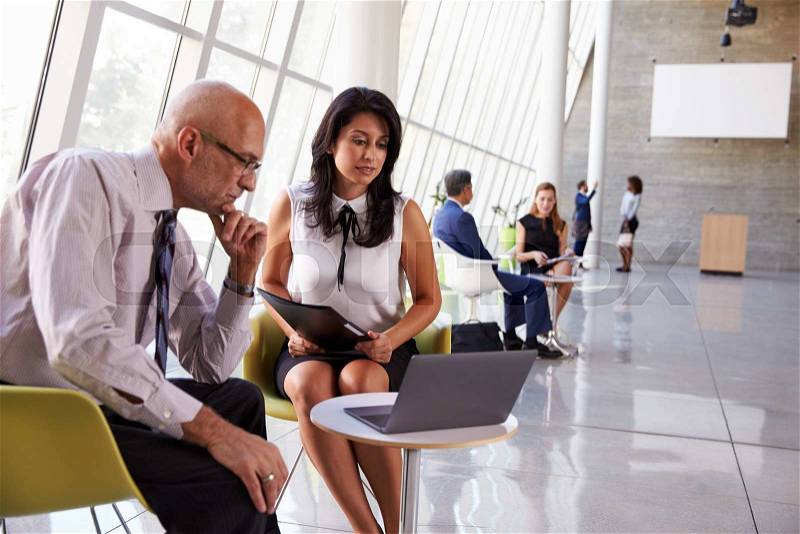 Business Meetings In Busy Office Foyer Area, stock photo