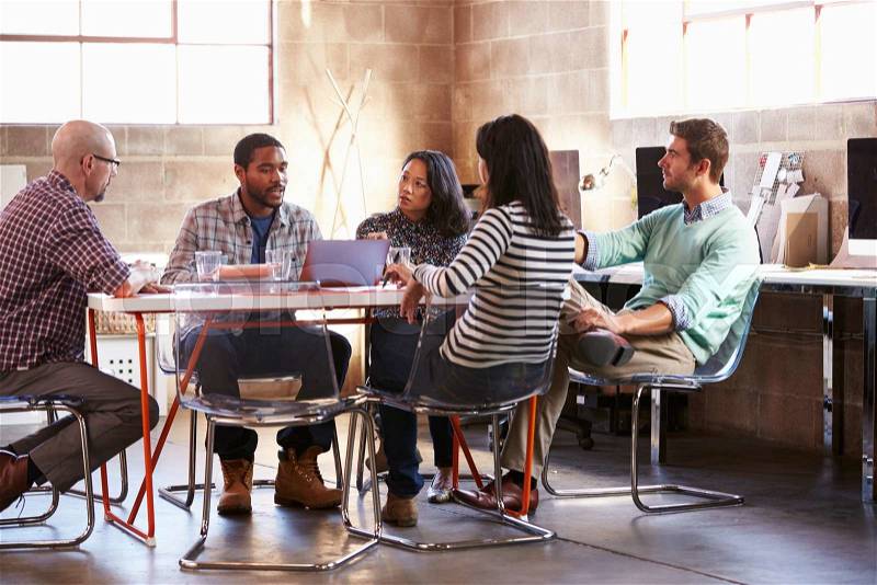 Group Of Designers Having Meeting Around Table In Office, stock photo