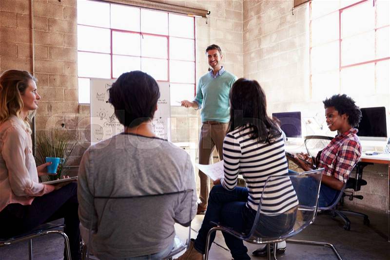 Group Of Designers Having Brainstorming Session In Office, stock photo