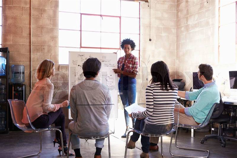 Group Of Designers Having Brainstorming Session In Office, stock photo