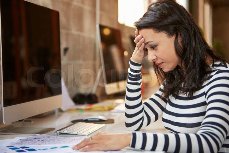 Stressed Female Designer Works At Computer In Modern Office, stock photo