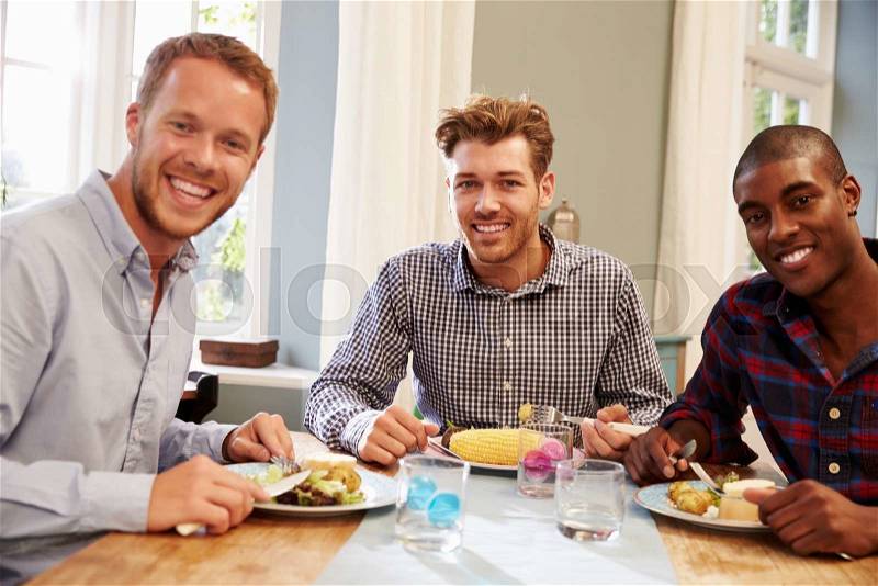 Male Friends At Home Sitting Around Table For Dinner Party, stock photo
