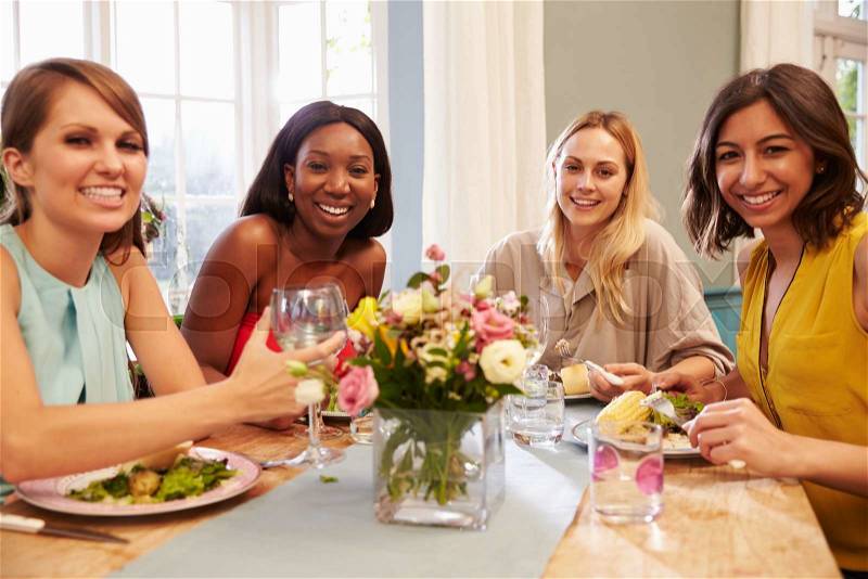Female Friends At Home Sitting Around Table For Dinner Party, stock photo