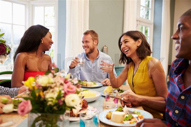Friends At Home Sitting Around Table For Dinner Party, stock photo