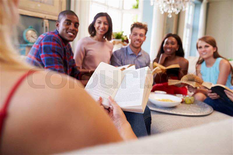 Group Of Friends Taking Part In Book Club At Home, stock photo