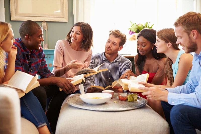 Group Of Friends Taking Part In Book Club At Home, stock photo