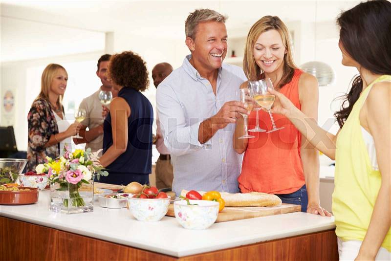 Mature Guests Being Welcomed At Dinner Party By Friends, stock photo